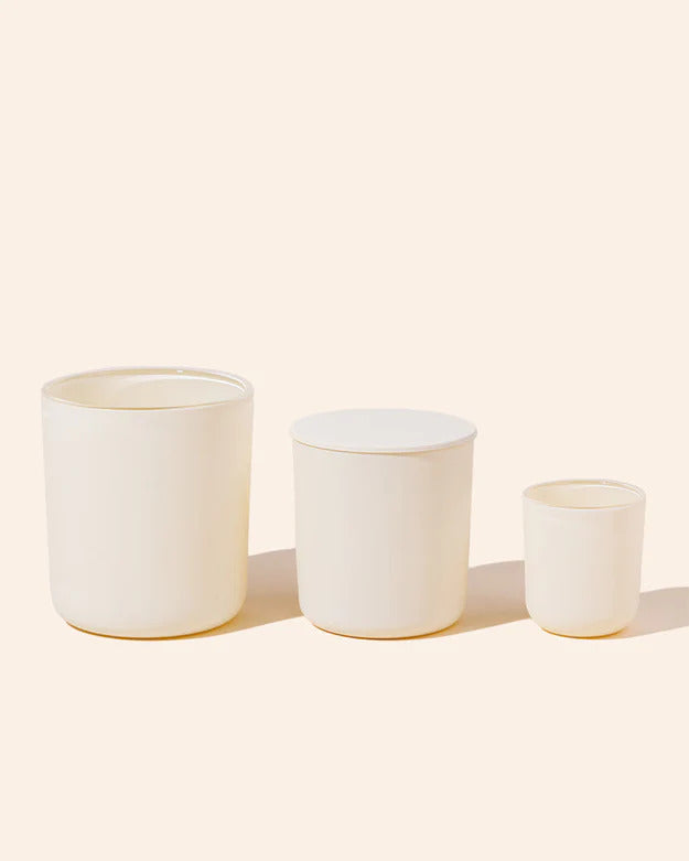 Noura Blanc Candles Cream colored jars in a row largest to smallest 12oz, 8oz, 2.5oz flat lay on ivory background