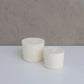 12 oz and 8oz aura jar candle refills next to one another smaller in front flat lay image with neutral background