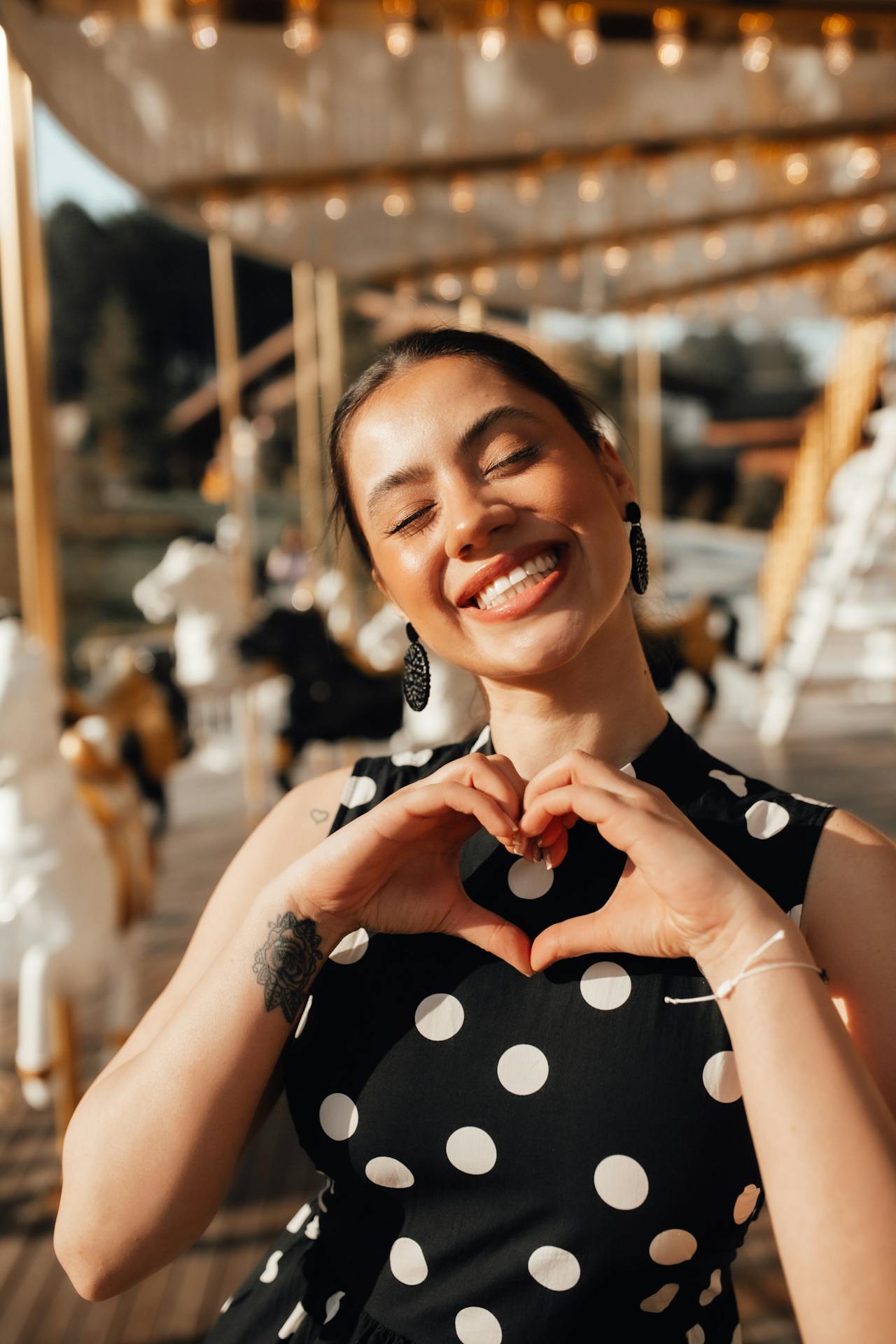 woman looking happy holding up heart hands