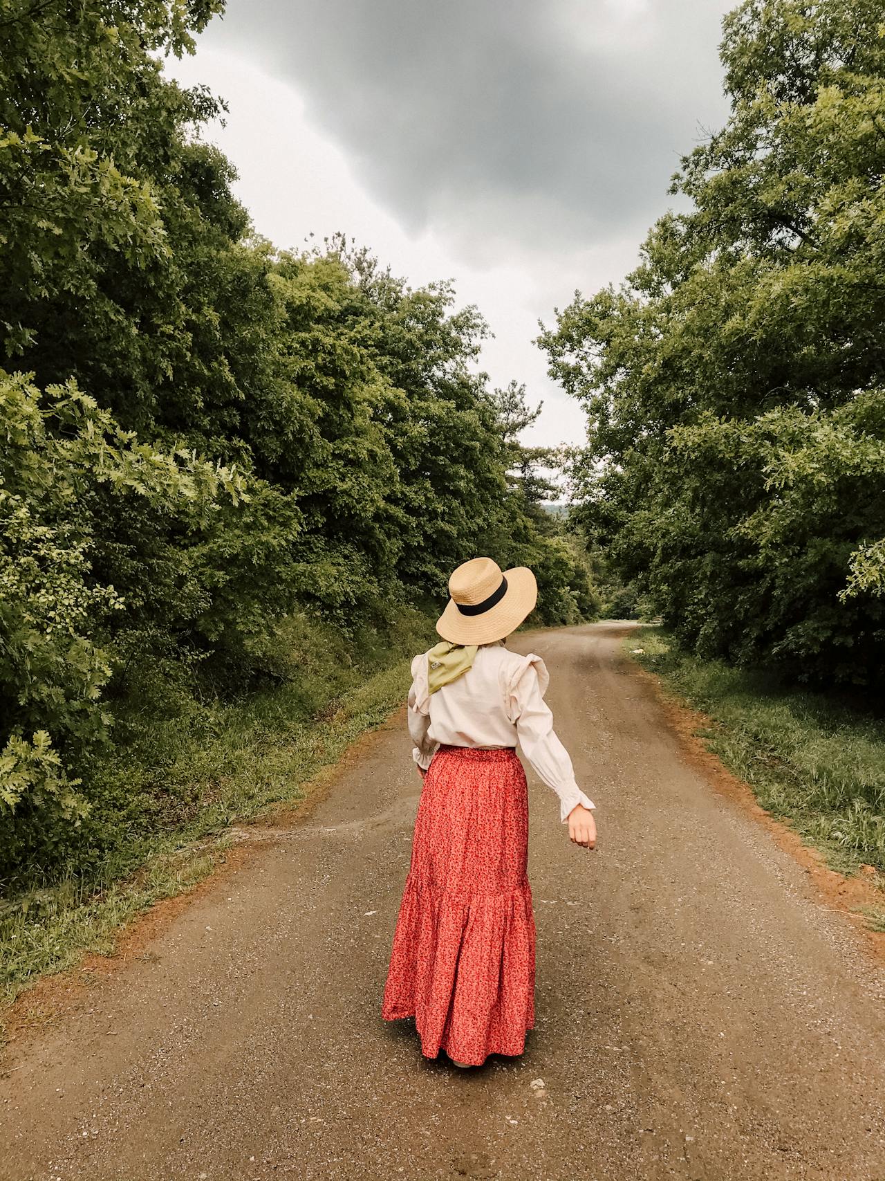 Woman taking a peaceful walk along dirt road as she enjoys life.